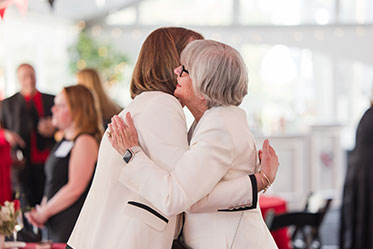 Two women embrace each other. Links to Gifts from Retirement Plans