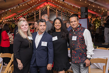 Four people standing together at an event. Links to Donor-Advised Funds