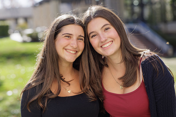 Two students smile together. Links to Gifts of Life Insurance
