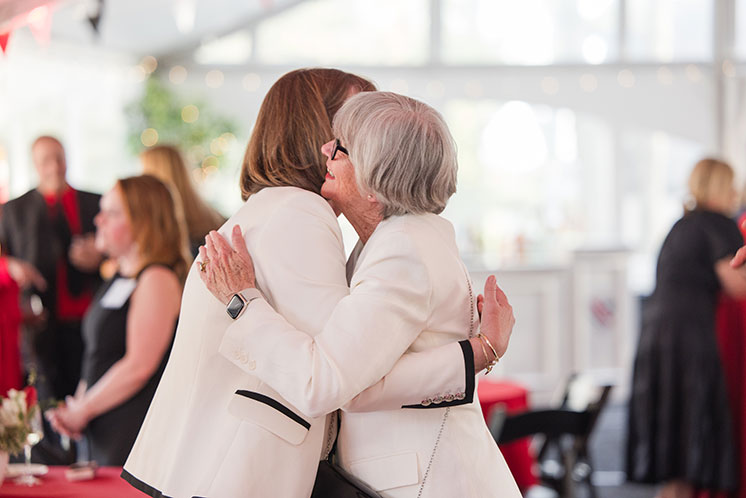Two women embrace each other. Links to Gifts from Retirement Plans