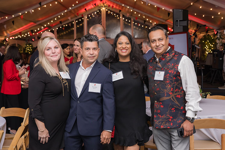 Four people standing together at an event. Links to Donor-Advised Funds